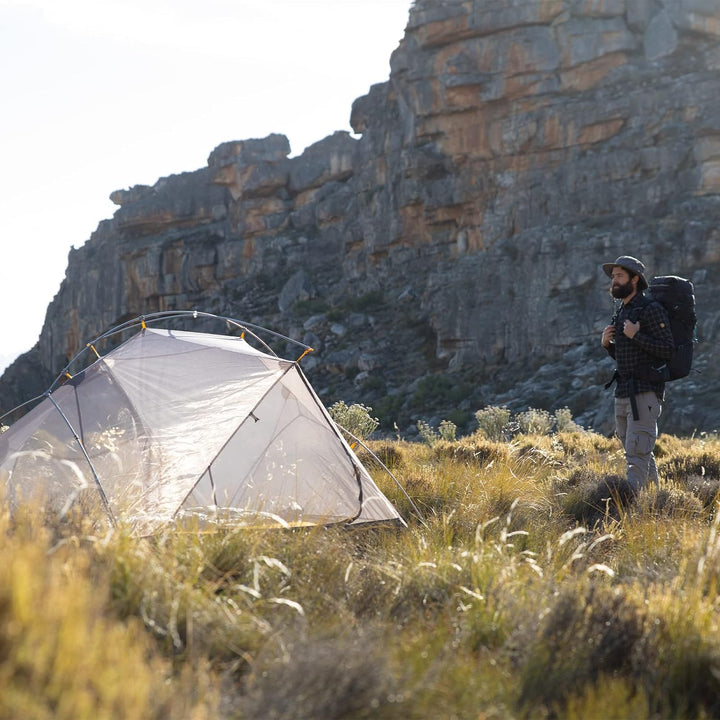 A man with a backpack standing at the Mongar Backpacking Tent