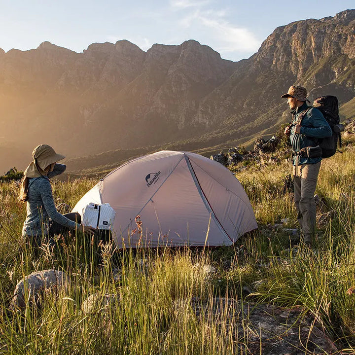 The two were enjoying a sunny day as they set up their Star-River 4-Season Backpacking Tent at the foot of the mountain. The magnificent mountains in the background added a touch of natural beauty to their camping trip.